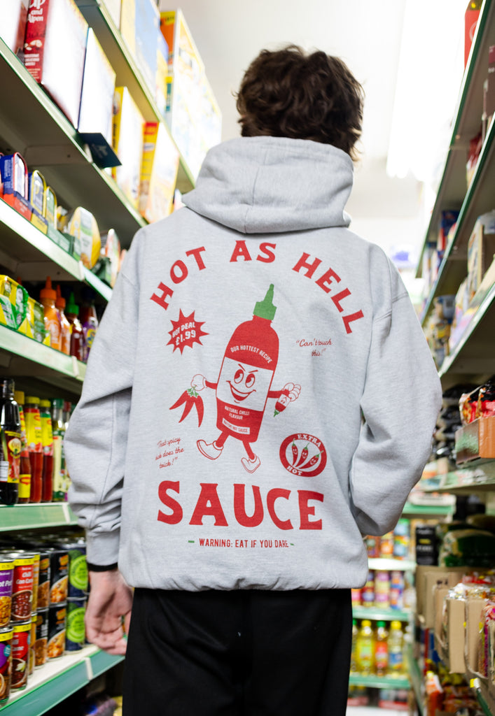 model wears unisex grey hoodie with printed hot sauce logo print to back and vintage style character