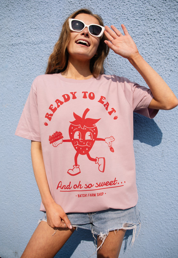 model wears purple pastel tee with strawberry logo and ready to eat slogan