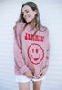 Model wears dusty pink sweatshirt with Jammin slogan and happy face biscuit graphic 