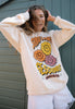 model wears vanilla coloured sweater with vintage style sunflower print