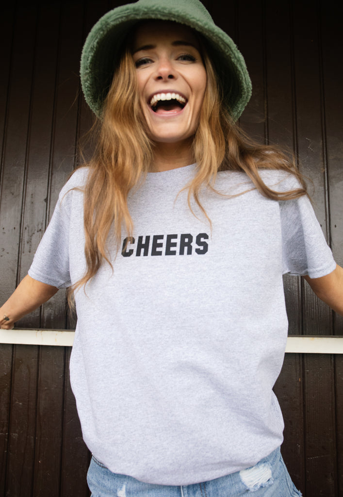 Model wears grey tshirt with Cheers slogan