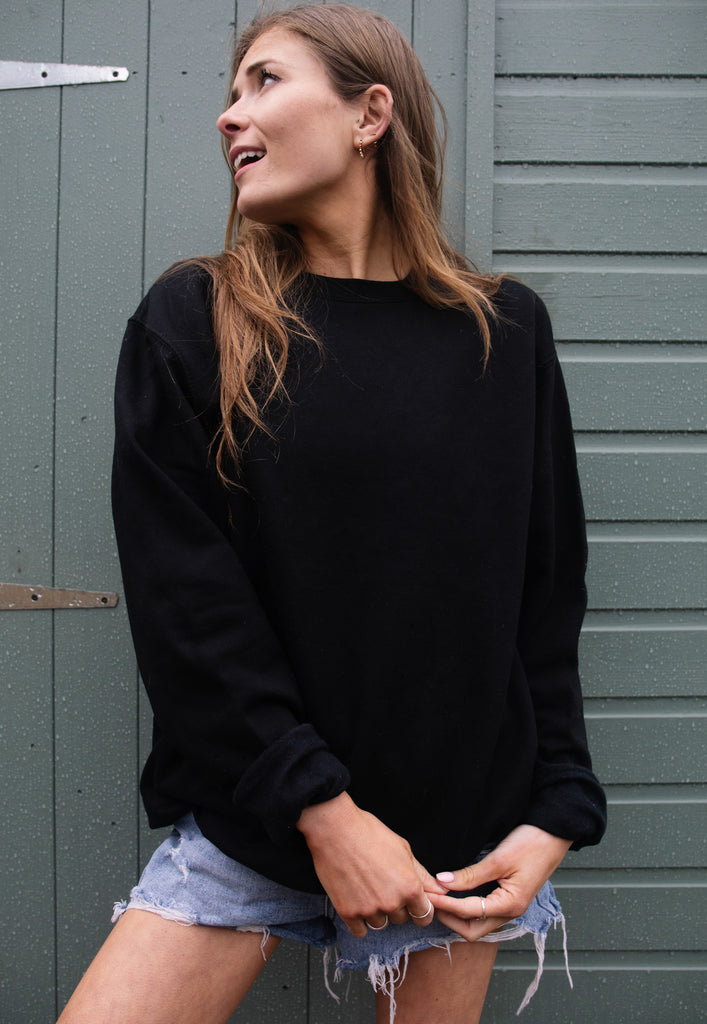 Model wears black sweatshirt with printed neon Garden Beats back print slogan