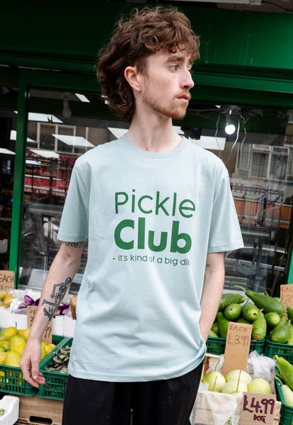 Model wears pickle club slogan tshirt in dusty green