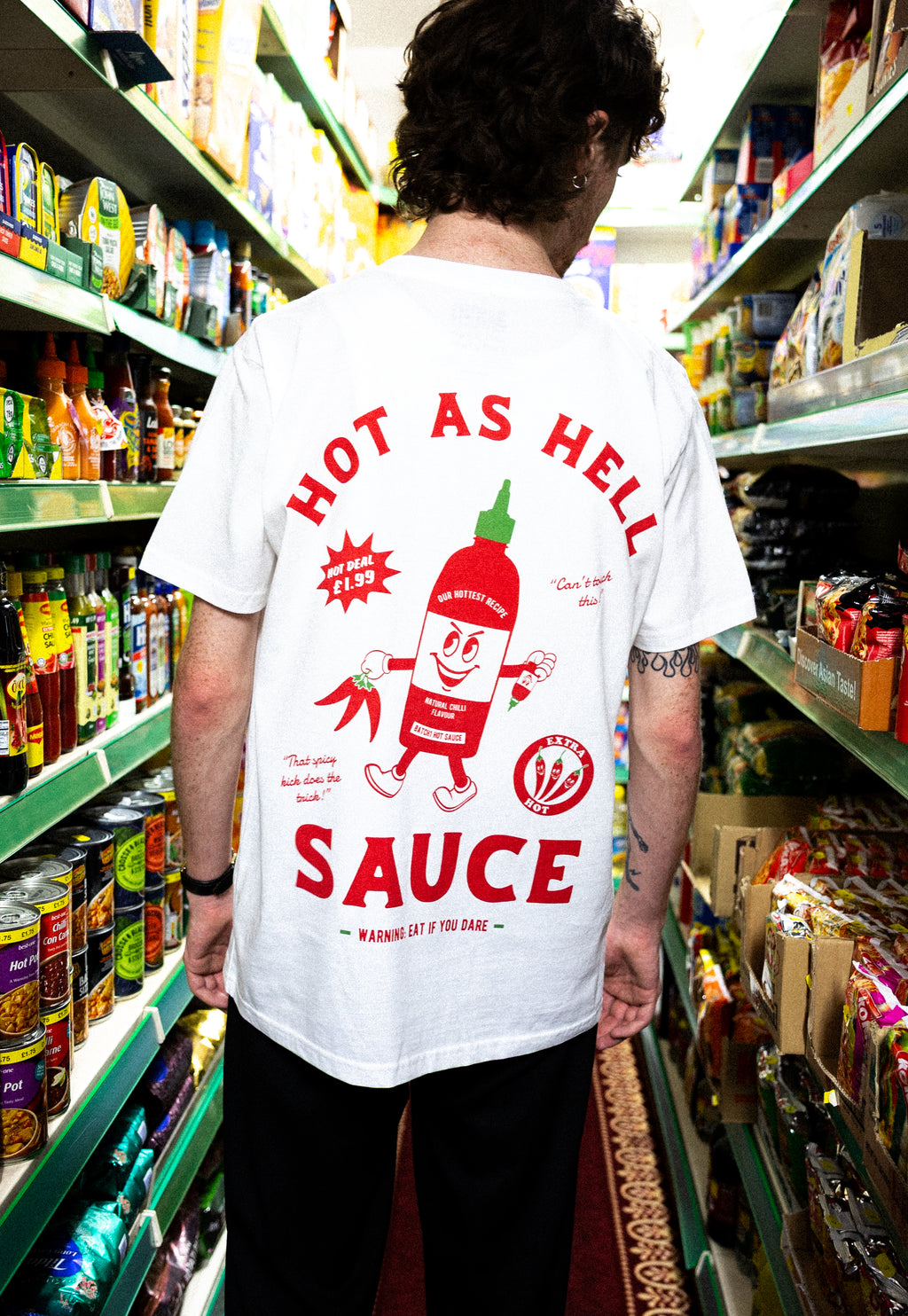 Model wearing white cotton t-shirt with sriracha bottle graphic character in red
