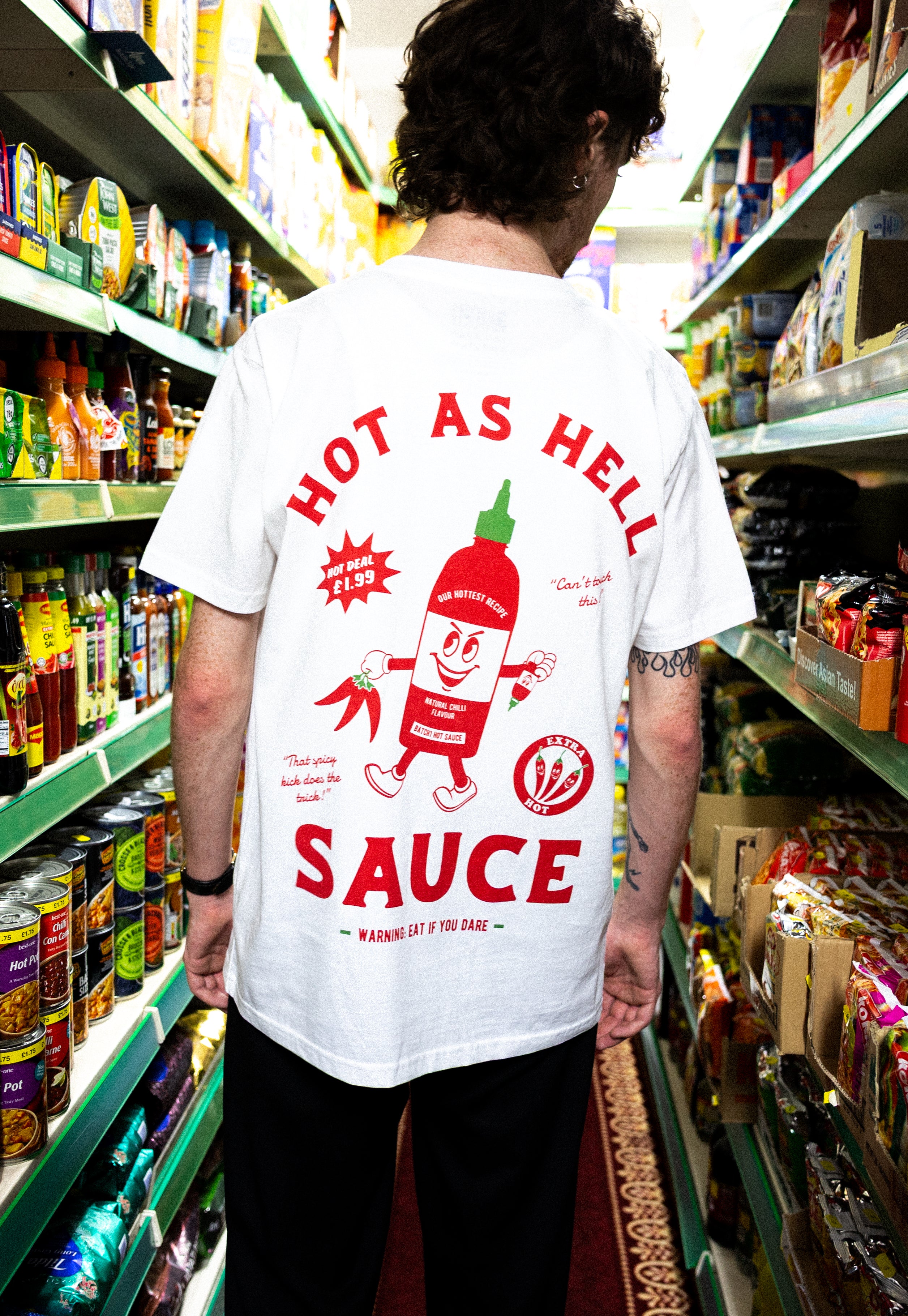 Model wearing white cotton t-shirt with sriracha bottle graphic character in red