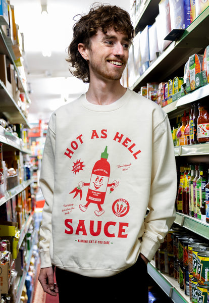 male model wears cream sweatshirt with hot sauce character graphic logo print