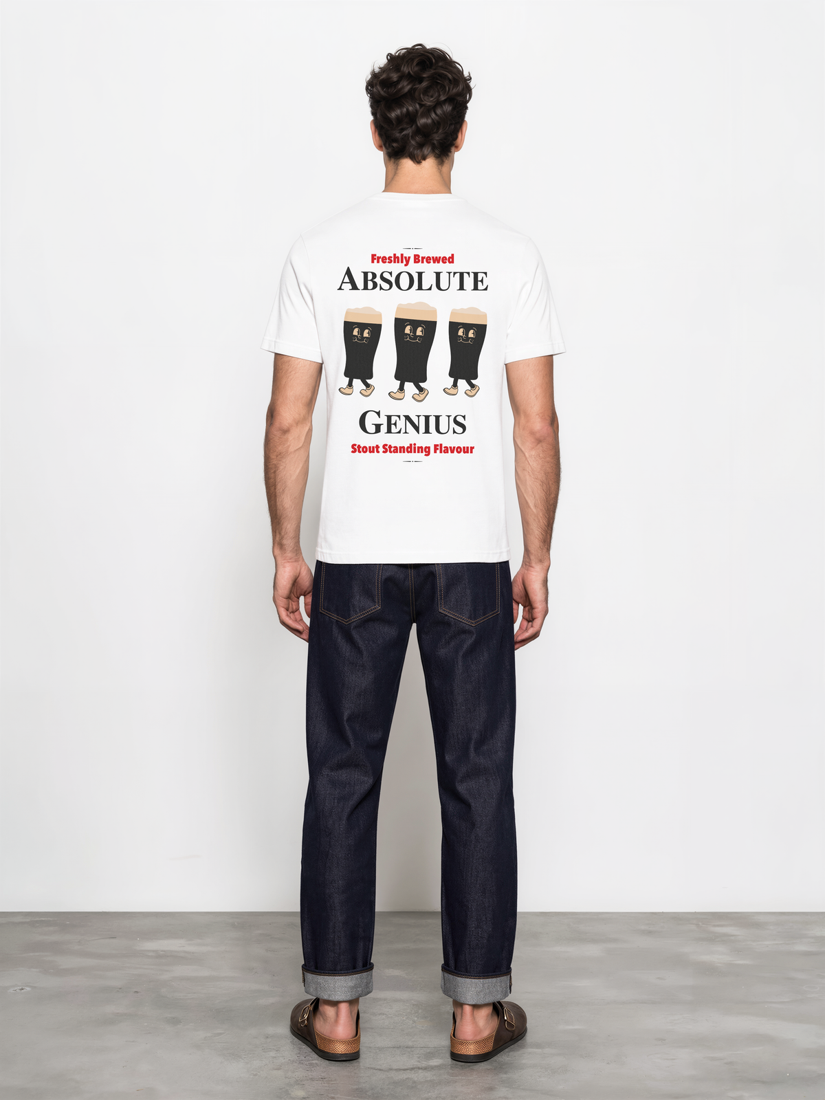 Male model wearing the white Absolute Genius T-shirt, back view with three stout characters and Absolute Genius lettering.