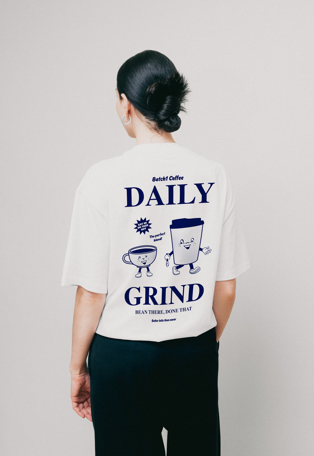 Model wearing white Daily Grind graphic boxy t-shirt with coffee cup design