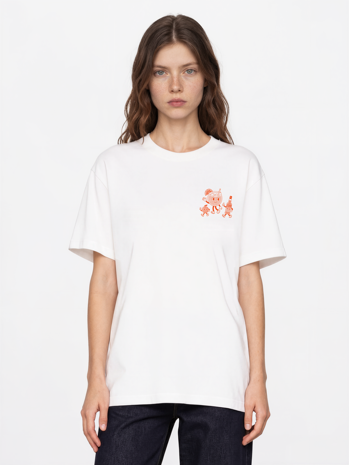 Aperol Spritz white T-shirt, female model front, showing a small orange cocktail character print on the left chest