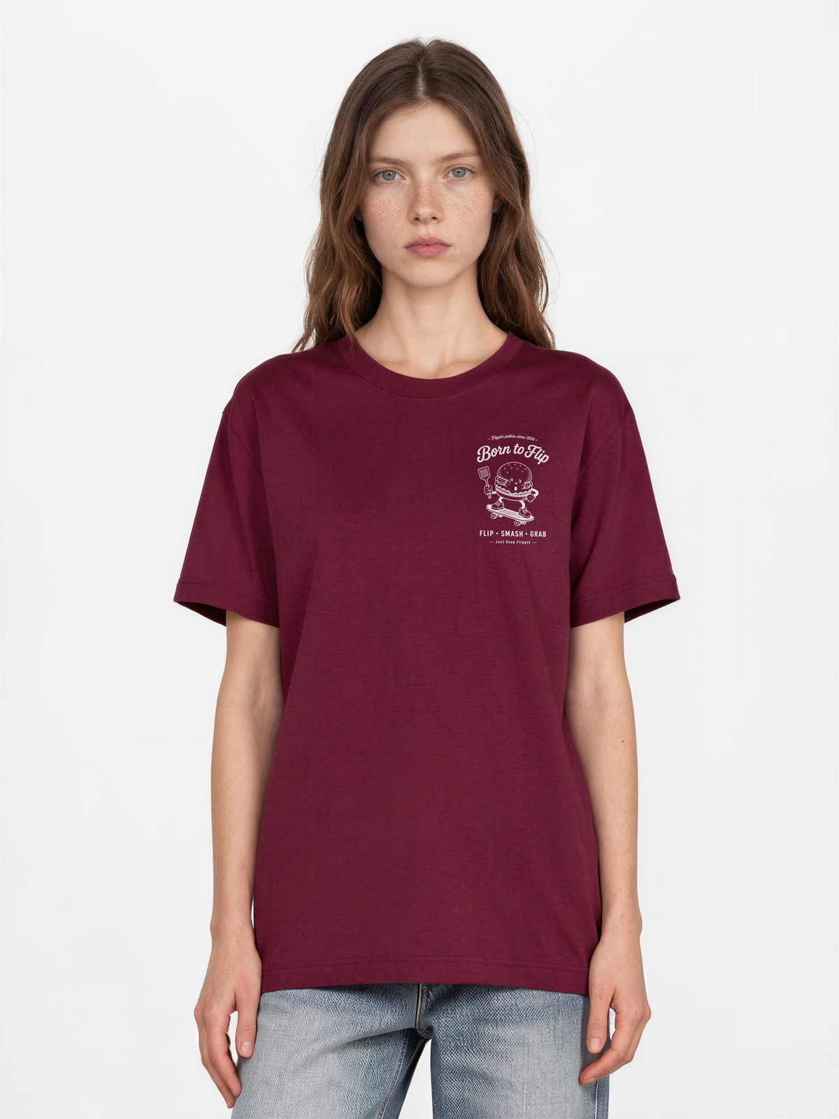 Female model wearing the Born to Flip burgundy T-shirt, front view with small white burger artwork on the left chest.