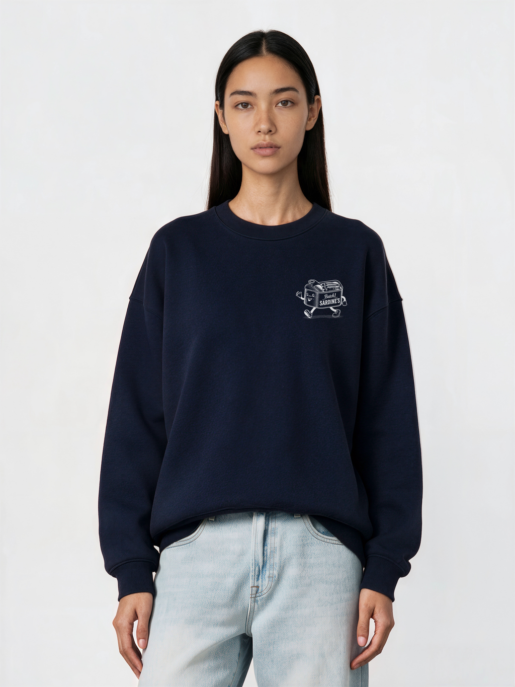 Brine and Dandy navy sweatshirt, front female model, showing a small white sardine-tin chest print