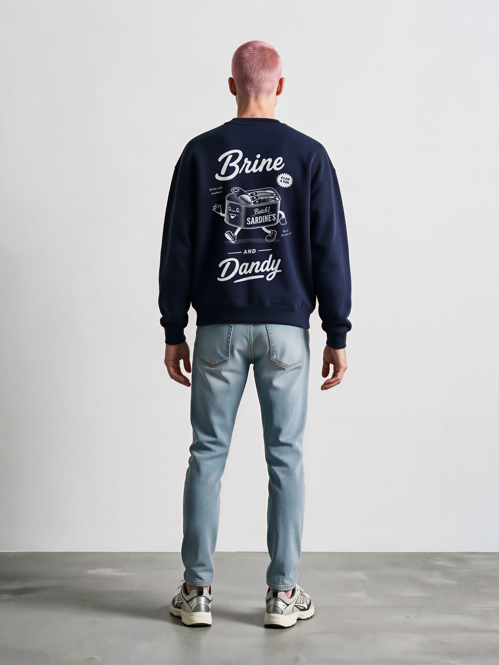 Brine and Dandy navy sweatshirt, back male model, showing the larger white Brine and Dandy sardine design on the back