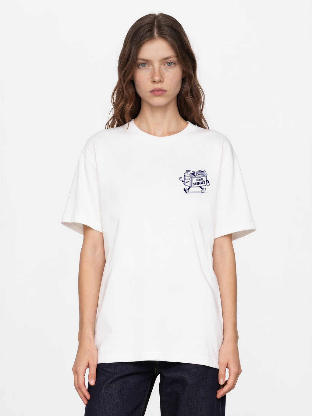 Brine and Dandy white T-shirt, front female model, showing a small navy sardine-tin chest print