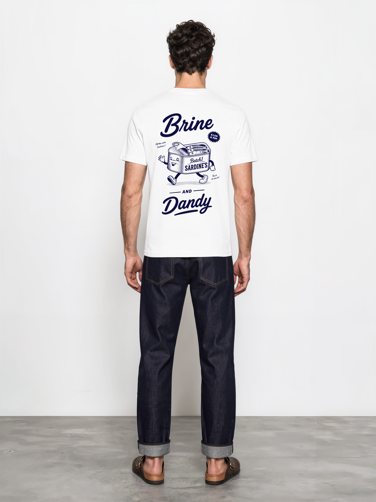 Brine and Dandy white T-shirt, back male model, showing the larger navy Brine and Dandy sardine design on the back