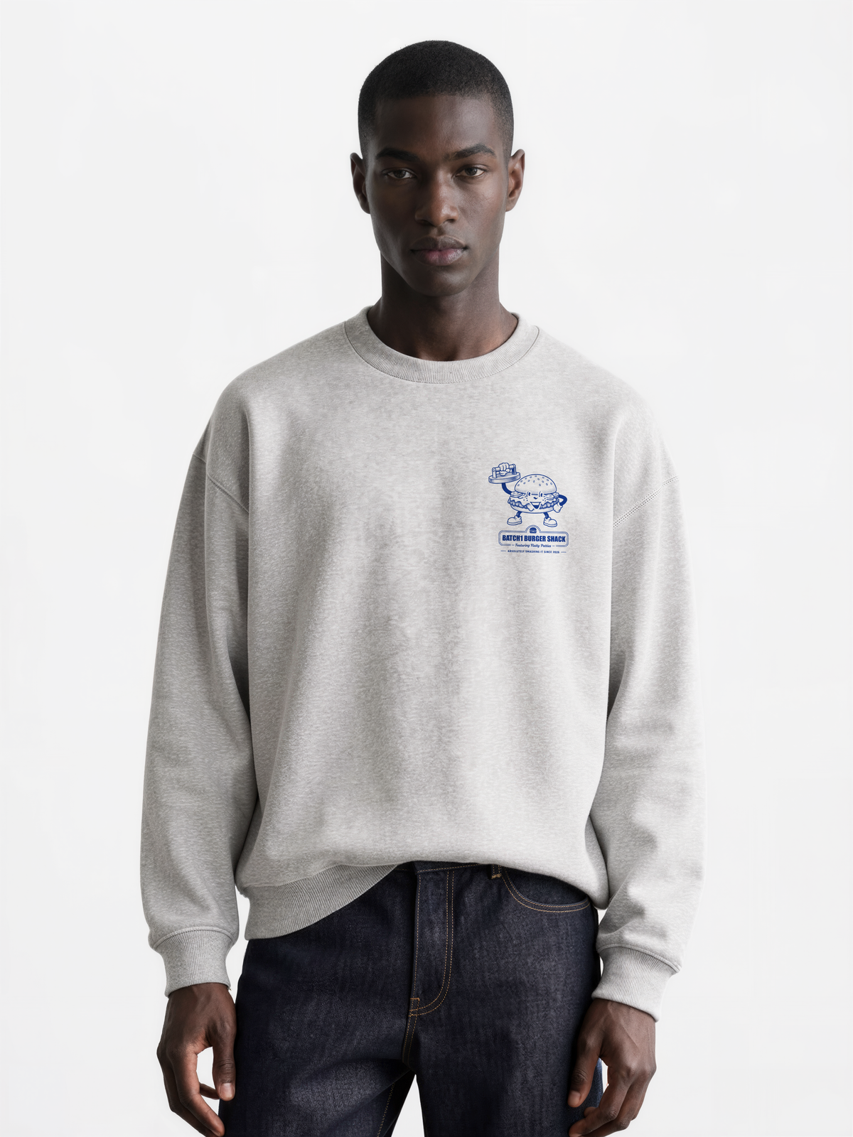 Male model wearing the Get Smashed ash oversized sweatshirt, front view showing the small blue burger graphic on the left chest.