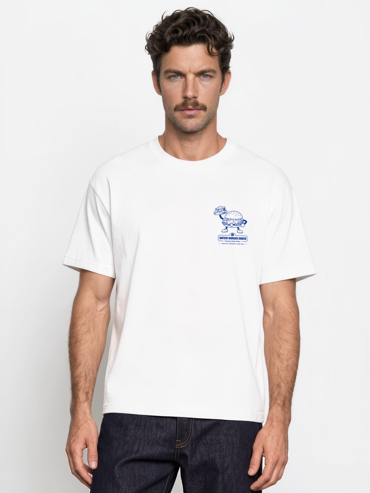 Male model wearing the Get Smashed white T-shirt, front view showing the small blue burger graphic on the left chest.