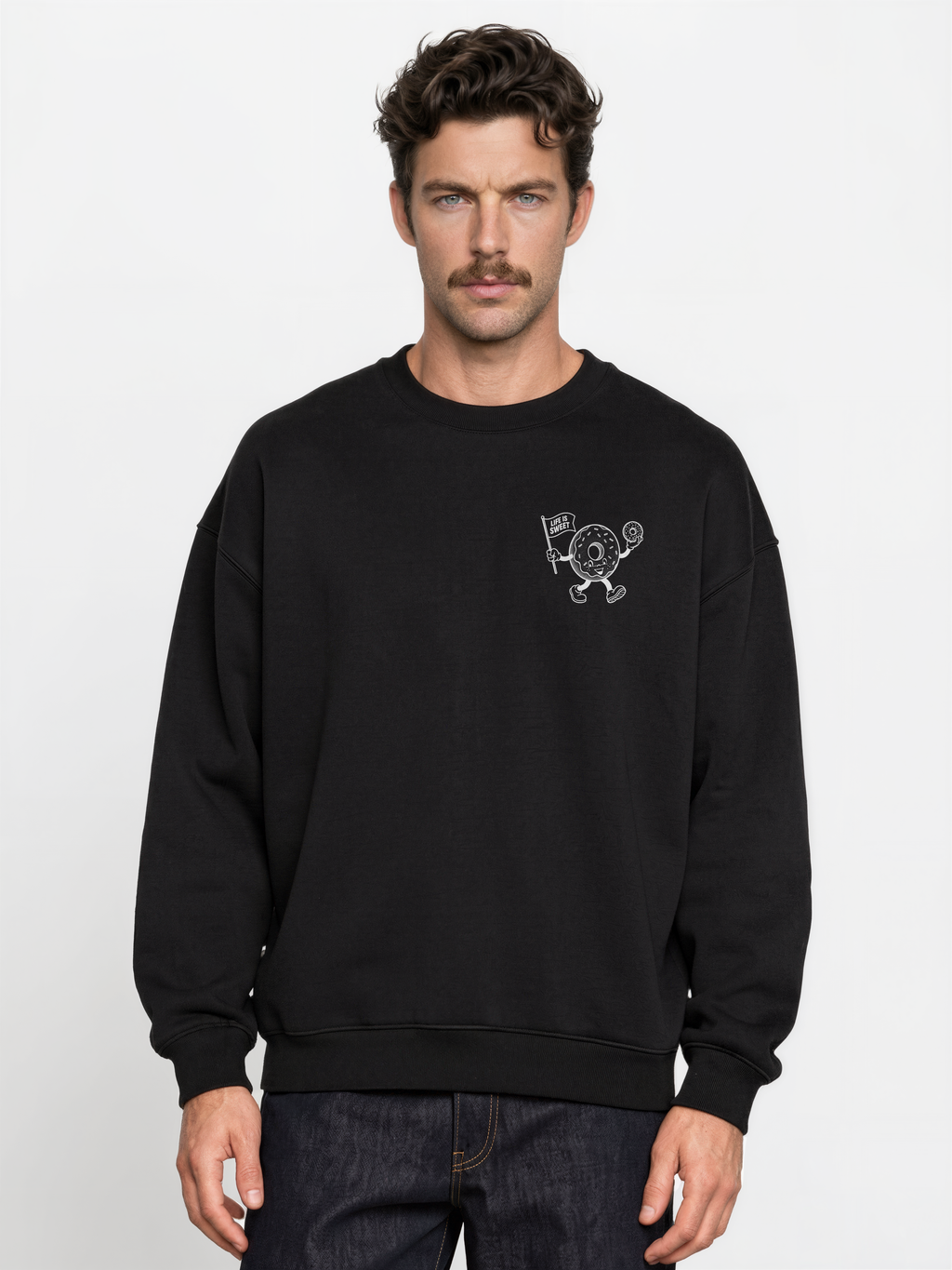 Glazy Days black sweatshirt, front male model, showing a small white doughnut character chest print