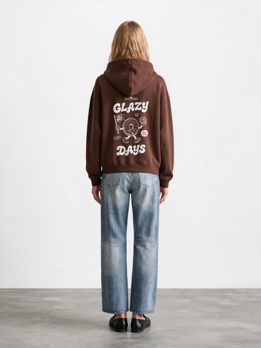 Glazy Days chocolate hoodie, back female model, showing the larger white Glazy Days doughnut design on the back