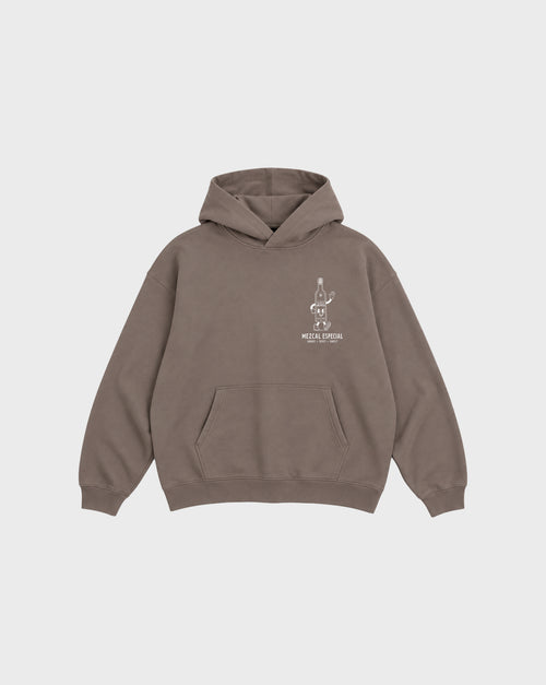 Front flat lay of the mocha Holy Smokes oversized hoodie with a white mezcal bottle graphic on the left chest