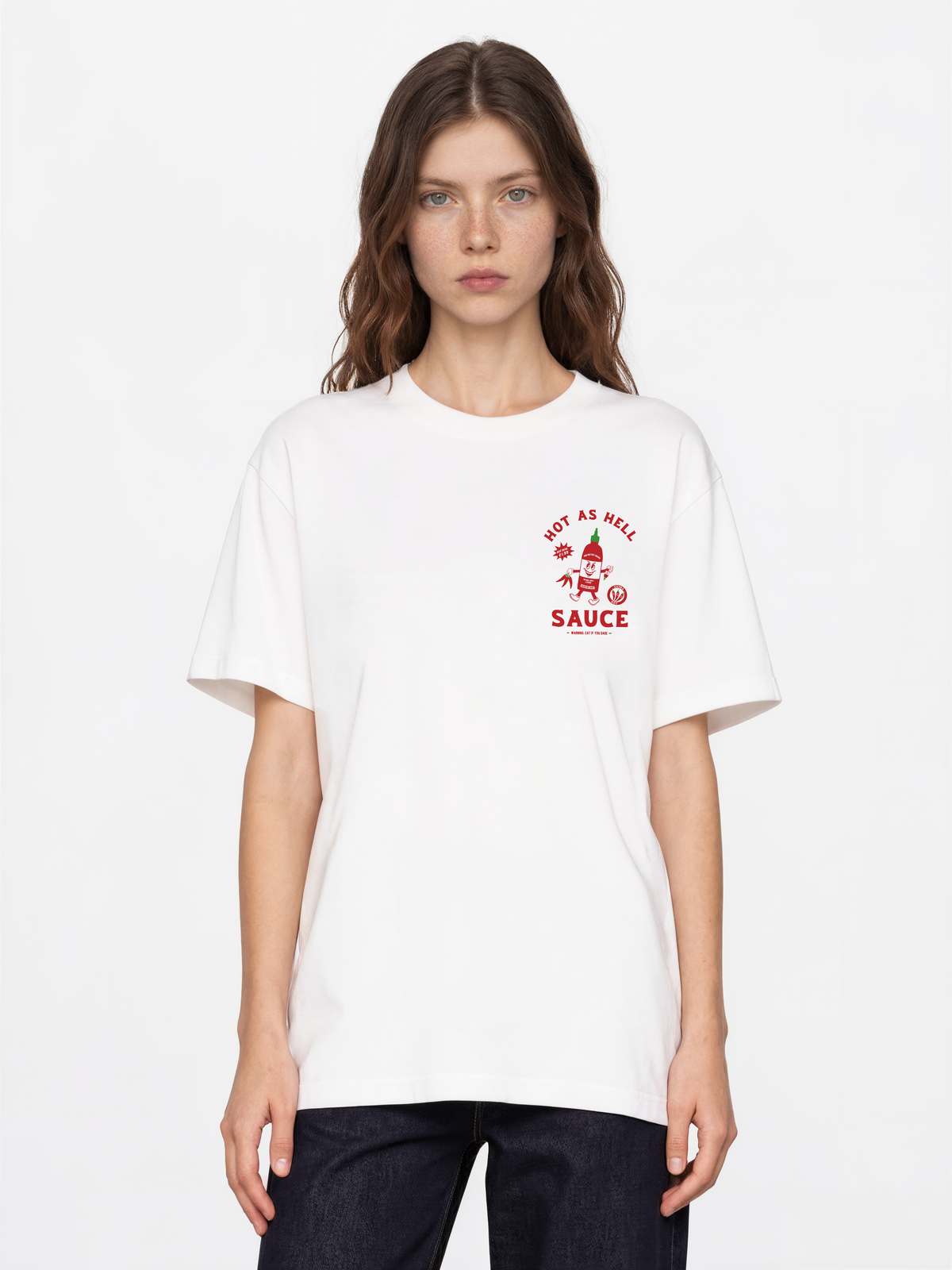 Hot Sauce white T-shirt, female front model, showing a small red and green Hot as Hell sauce bottle print on the left chest