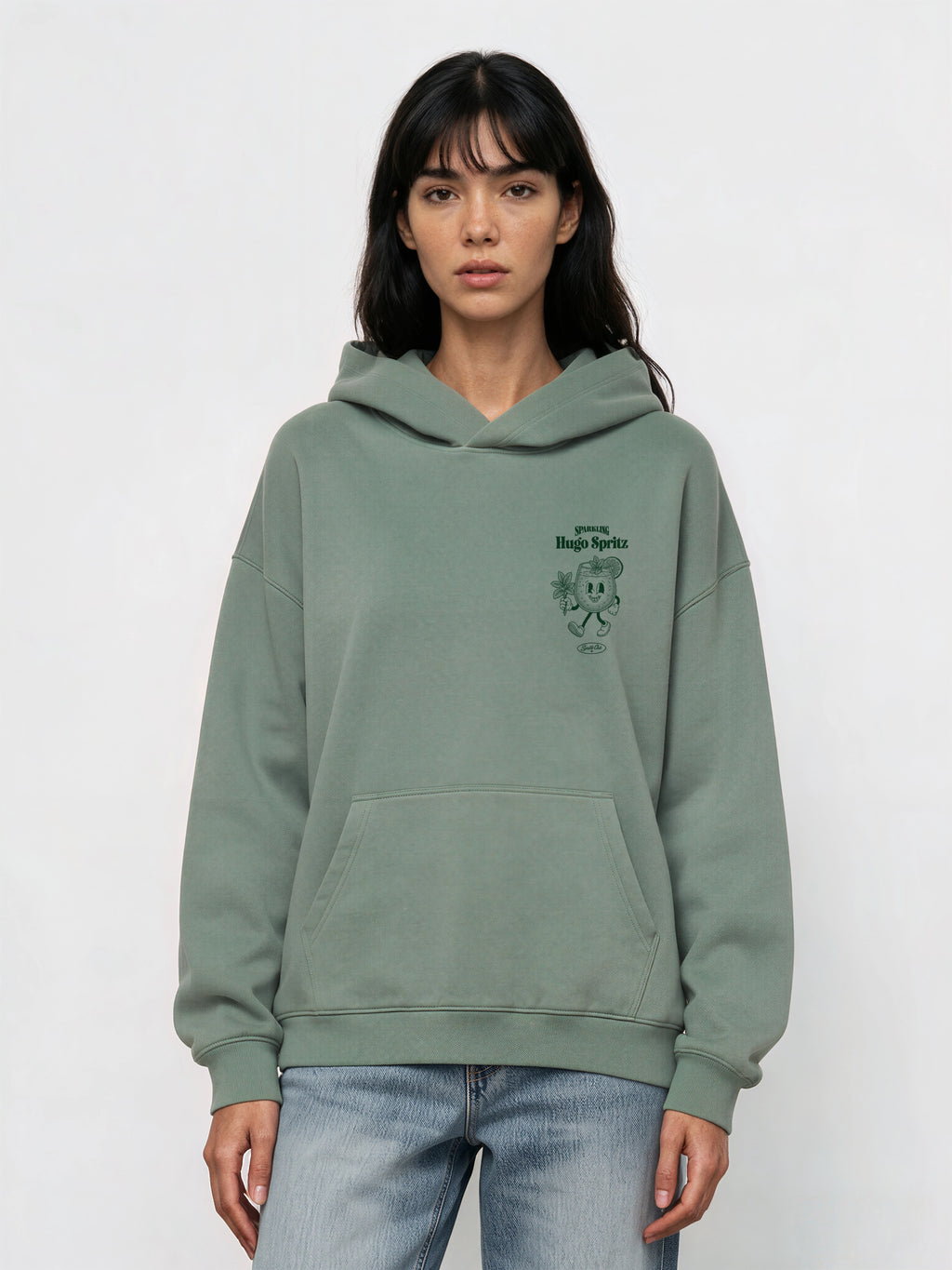 Female model wearing the Hugo Spritz Pine oversized hoodie, showing the green left chest print
