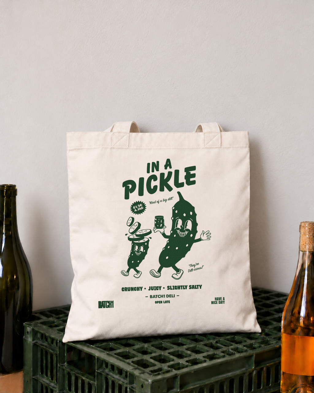 In a Pickle natural cotton tote bag with green deli-style artwork styled beside a wooden wine crate