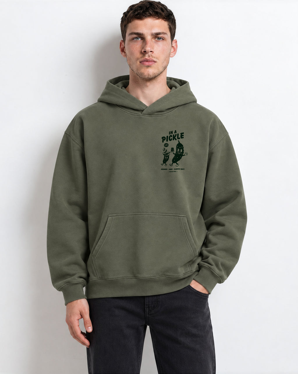Male model wearing the In a Pickle olive oversized hoodie, front view