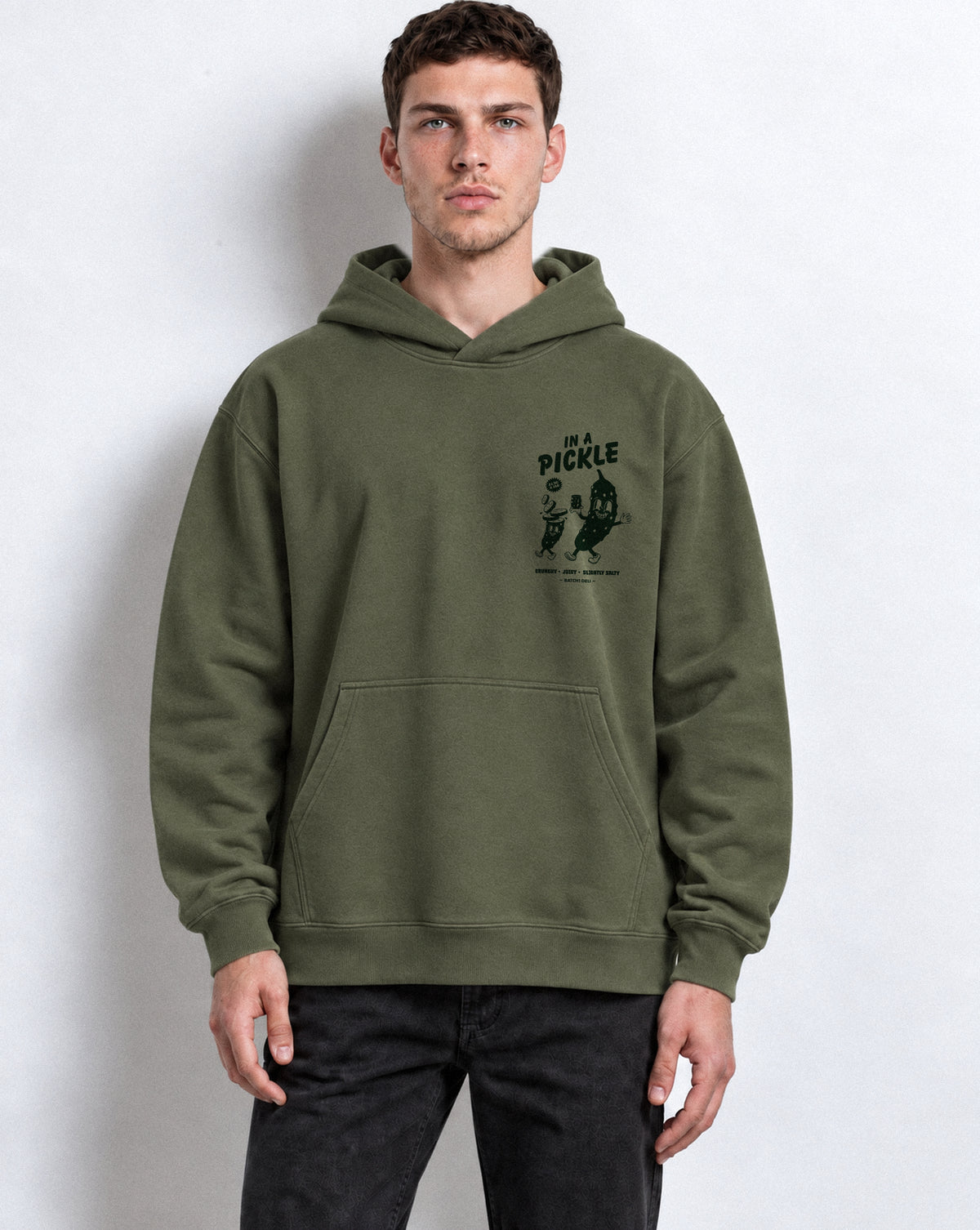 Male model wearing the Batch1 In a Pickle oversized Olive hoodie, front view with dark green left-chest print.