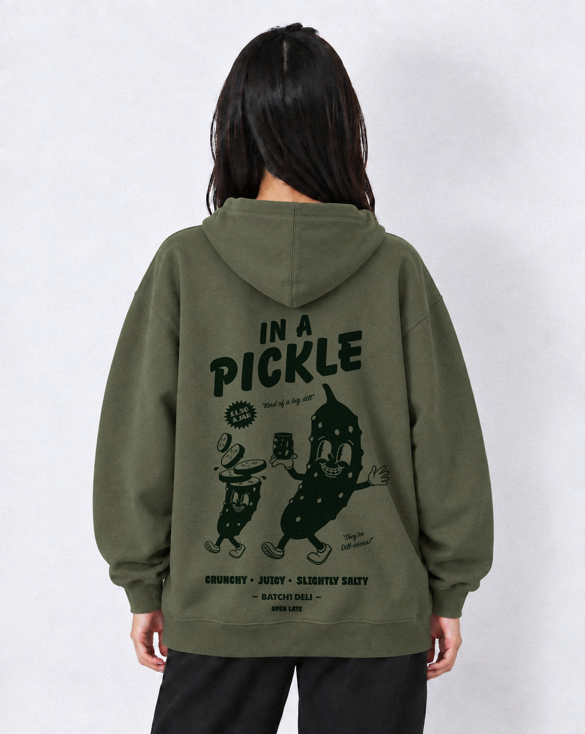 Female model wearing the Batch1 In a Pickle oversized Olive hoodie, back view with large dark green pickle graphic.