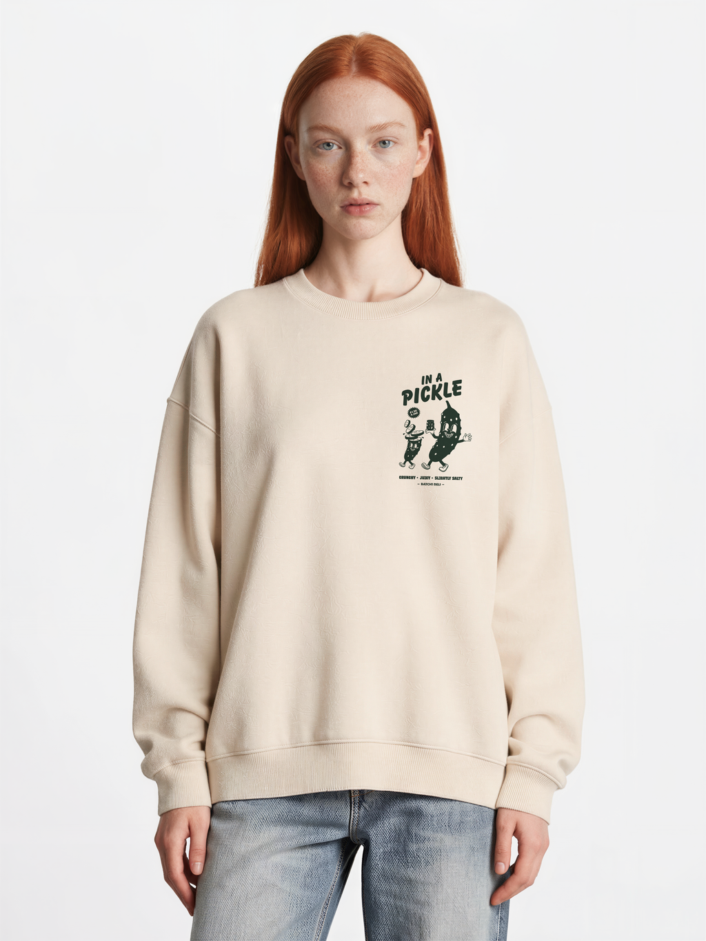 Female model wearing the Batch1 In a Pickle oversized Stone sweatshirt, front view with dark green left-chest print.