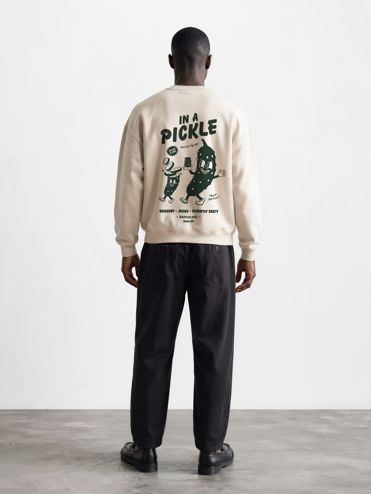 Male model wearing the Batch1 In a Pickle oversized Stone sweatshirt, back view with dark green large pickle graphic.