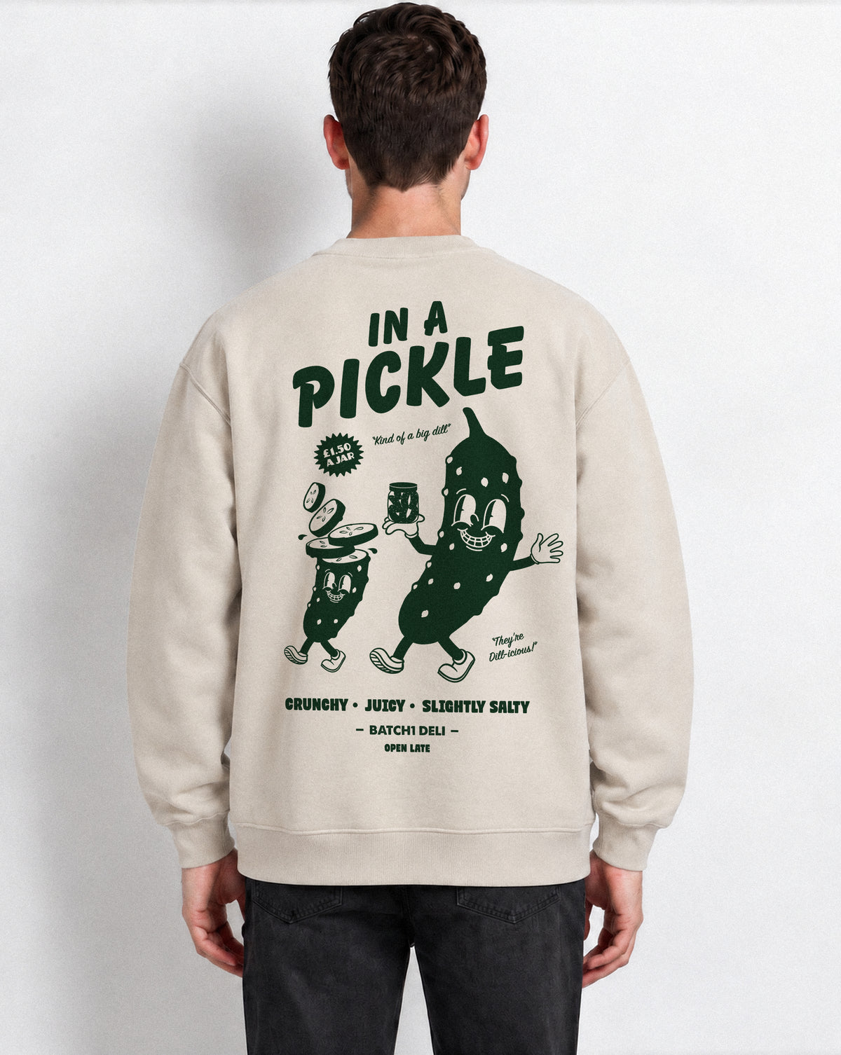 Male model wearing the In a Pickle oversized sweatshirt in Stone, back view with large back dark green graphic