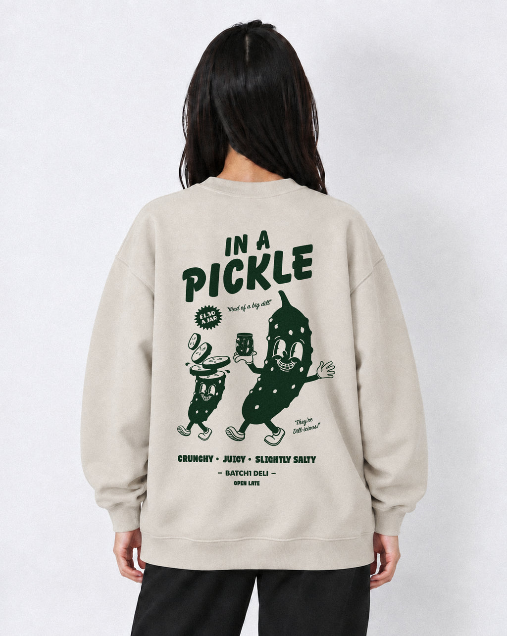 Female model wearing the In a Pickle oversized sweatshirt in Stone, back view with large back dark green graphic