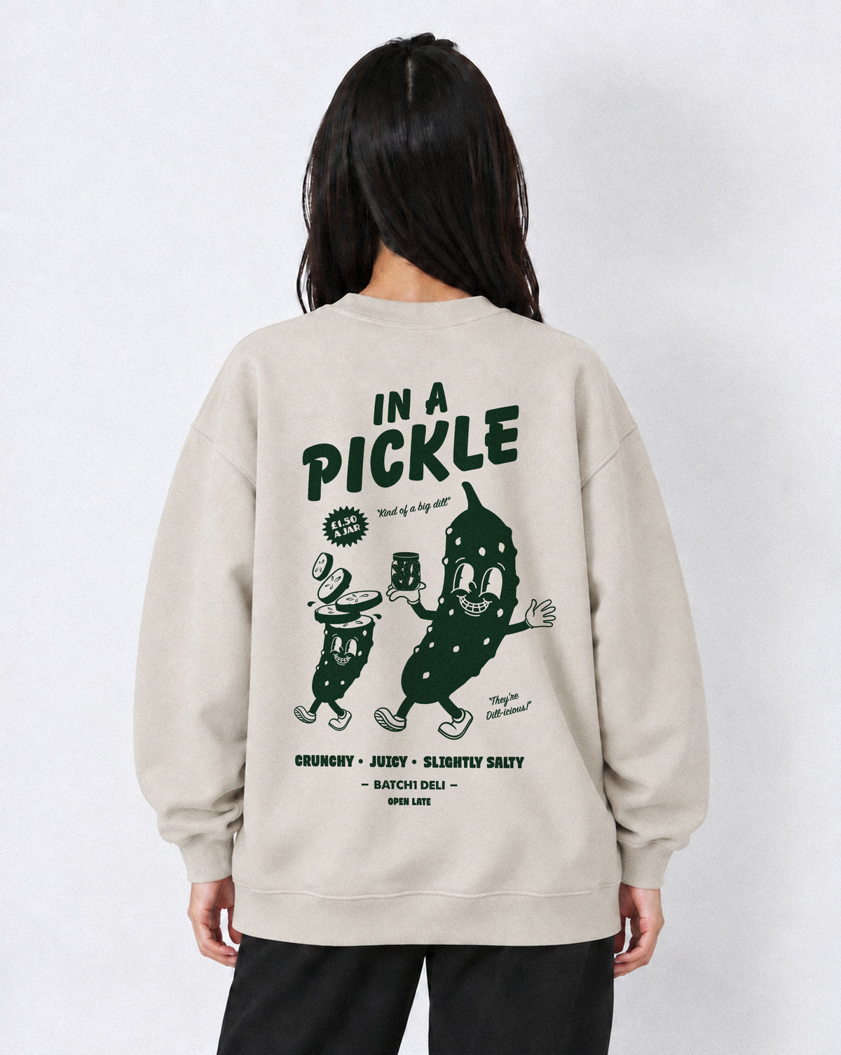 Female model wearing the In a Pickle oversized sweatshirt in Stone, back view with large back dark green graphic