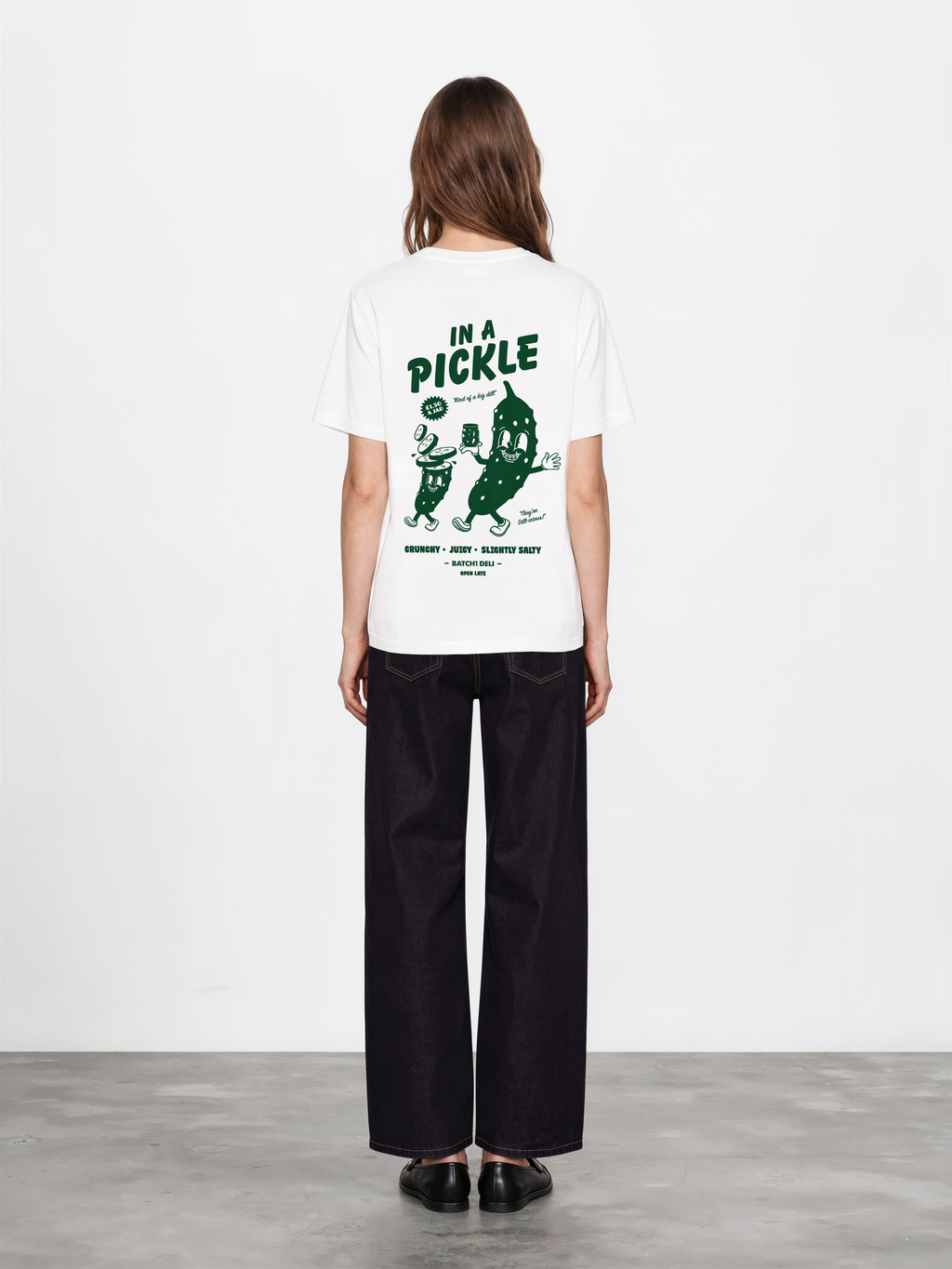 Female model wearing the Batch1 In a Pickle white T-shirt, back view with large dark green pickle graphic.