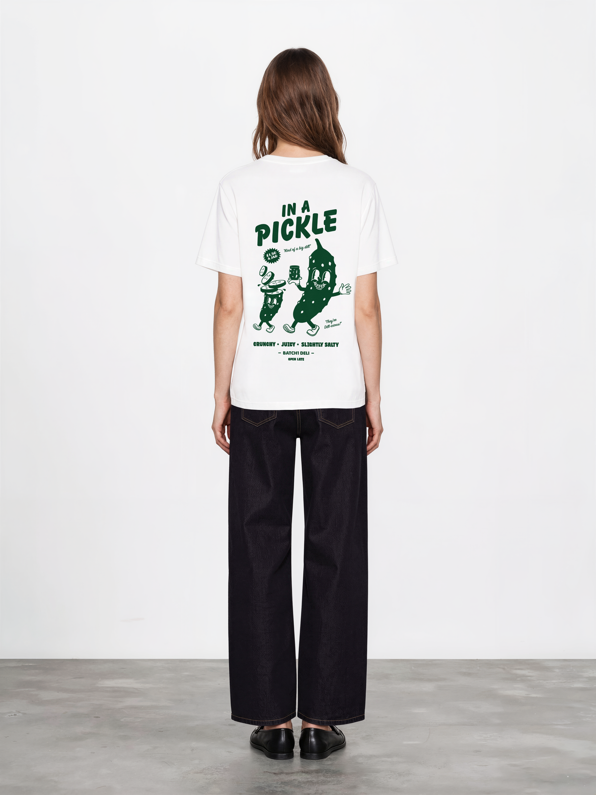 Female model wearing the Batch1 In a Pickle white T-shirt, back view with large dark green pickle graphic.