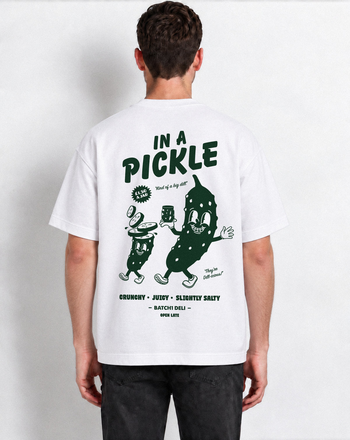 Male model wearing the Batch1 In a Pickle white T-shirt, back view with large dark green pickle graphic.