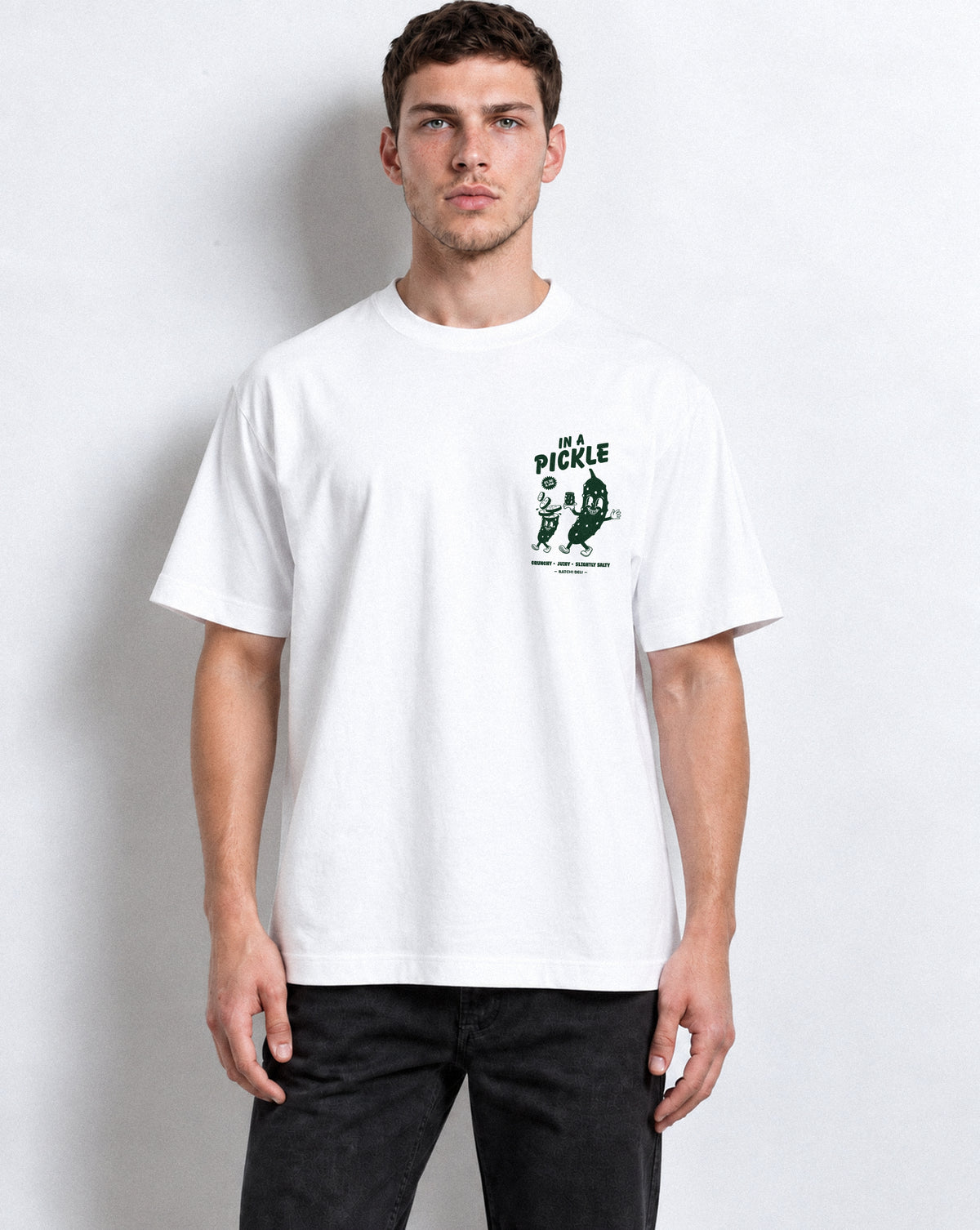 Male model wearing the Batch1 In a Pickle white T-shirt, front view with dark green left-chest print.