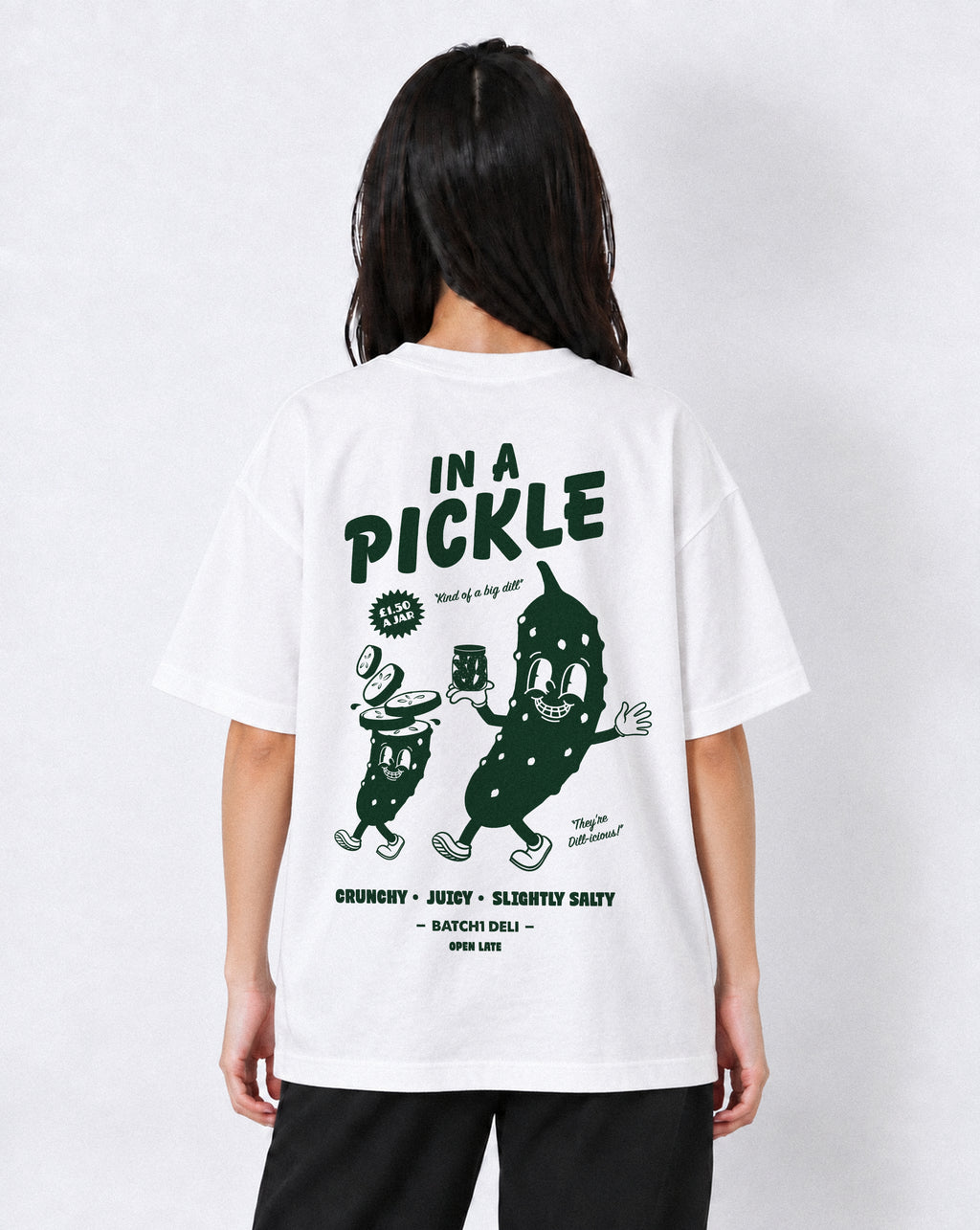 Female model wearing the Batch1 In a Pickle white T-shirt, back view with large dark green pickle graphic.