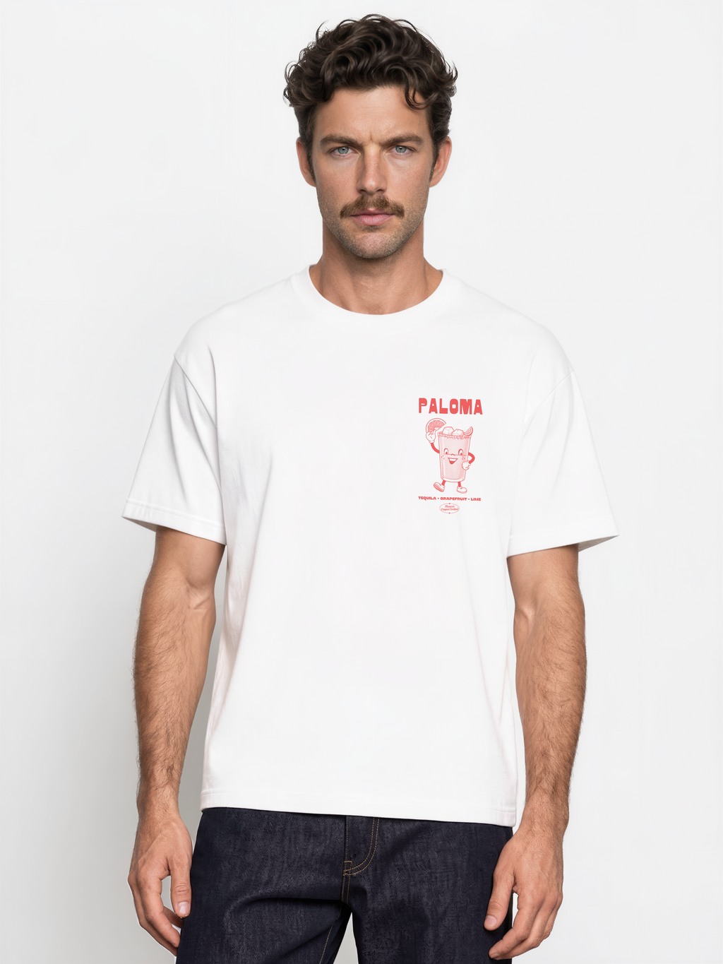 Male model wearing the Paloma white T-shirt, front view showing the coral left-chest cocktail print.