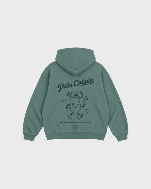Back flat lay of the Piña Colada pine oversized hoodie, showing the large teal tropical cocktail character and Piña Colada lettering on the back.