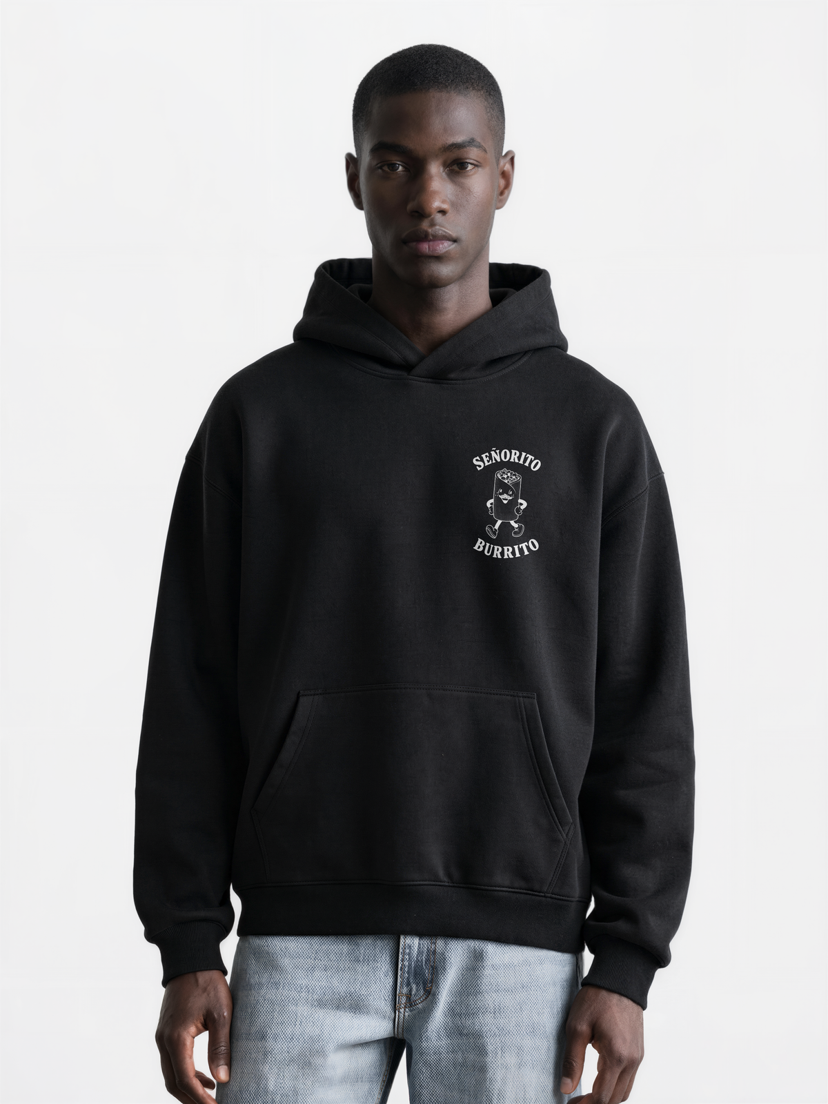 Male model wearing the Señorito Burrito black oversized hoodie, front view showing the white left-chest burrito artwork.