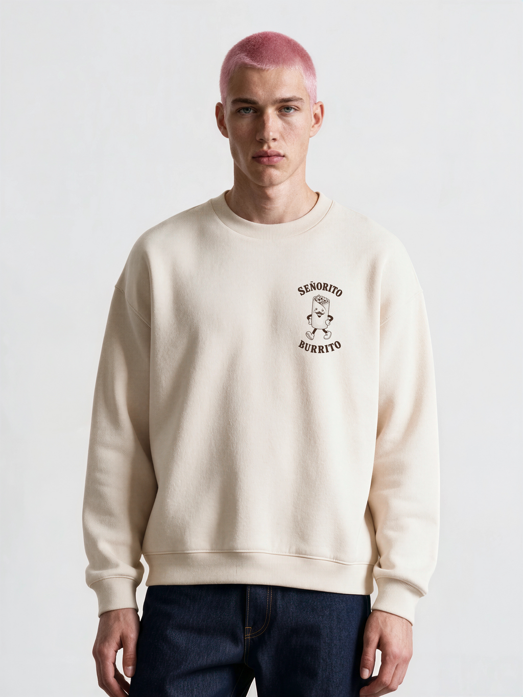 Male model wearing the Señorito Burrito ivory oversized sweatshirt, front view showing the dark brown left-chest burrito artwork.