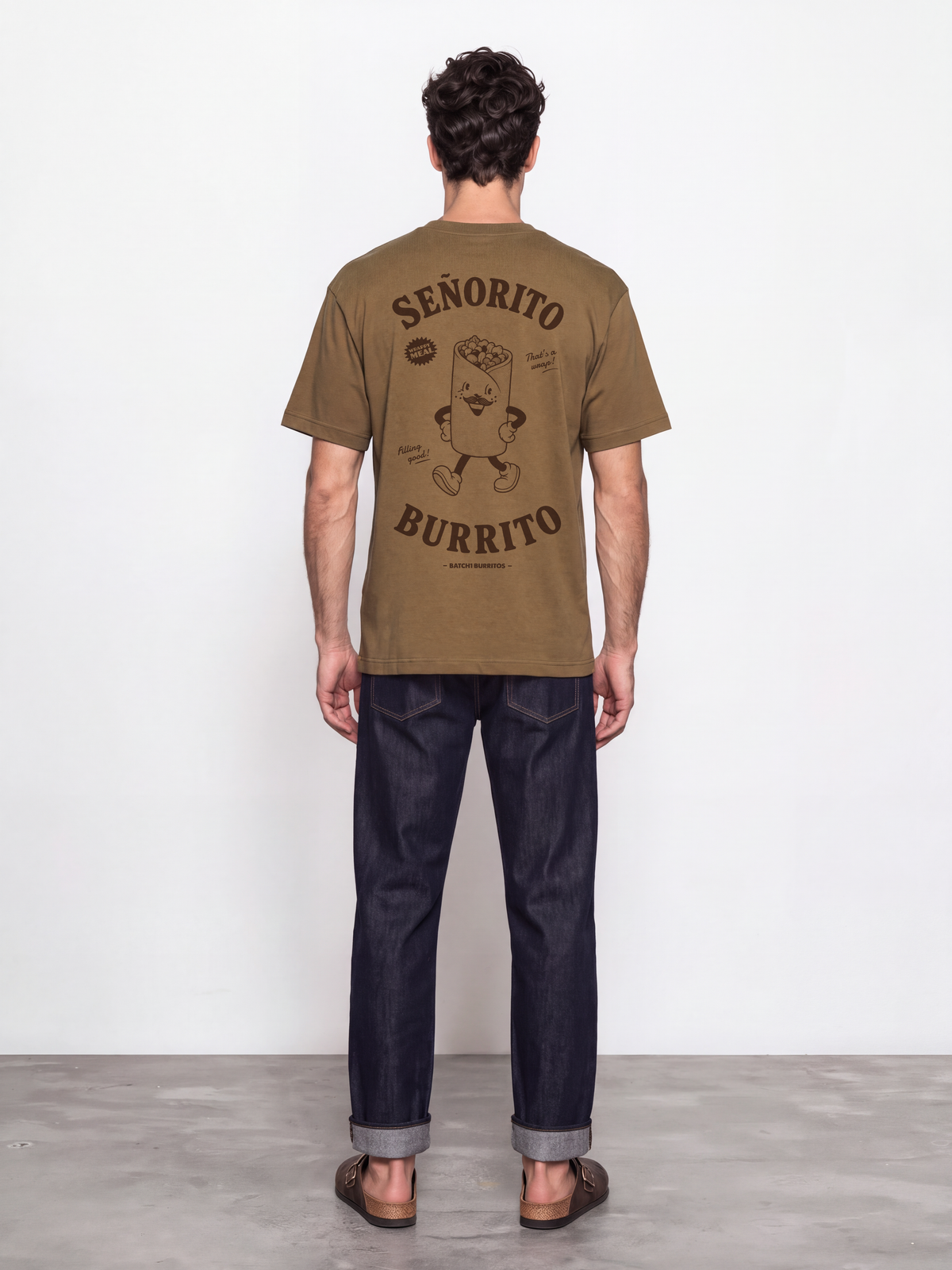 Male model wearing the Señorito Burrito tobacco t-shirt, back view showing the dark brown large burrito character and lettering.