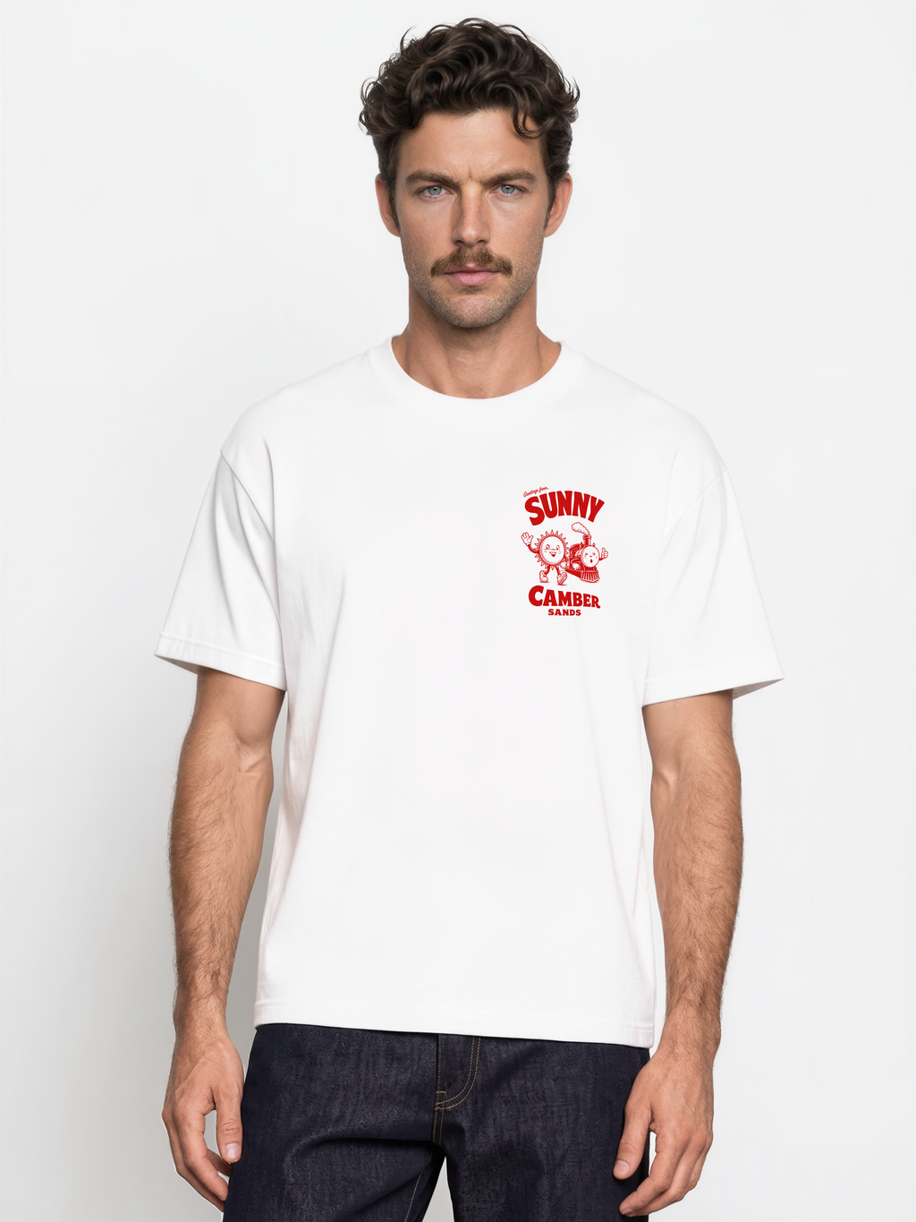 Sunny Camber Sands white T-shirt, front male model view, showing a small red sun and steam train chest print