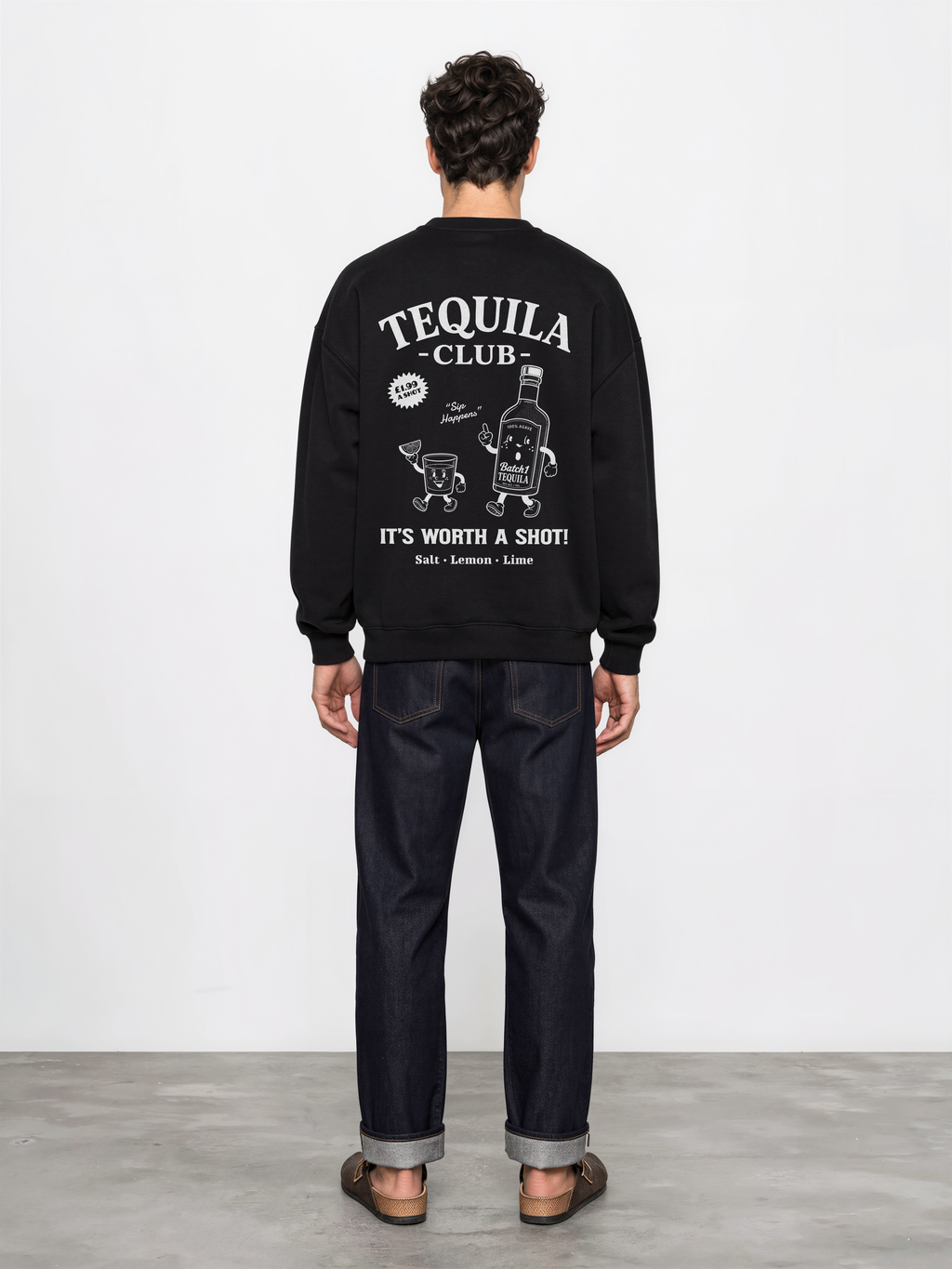 Male model wearing the black Tequila Club oversized sweatshirt, back view showing the large white tequila bottle and shot-glass graphic.