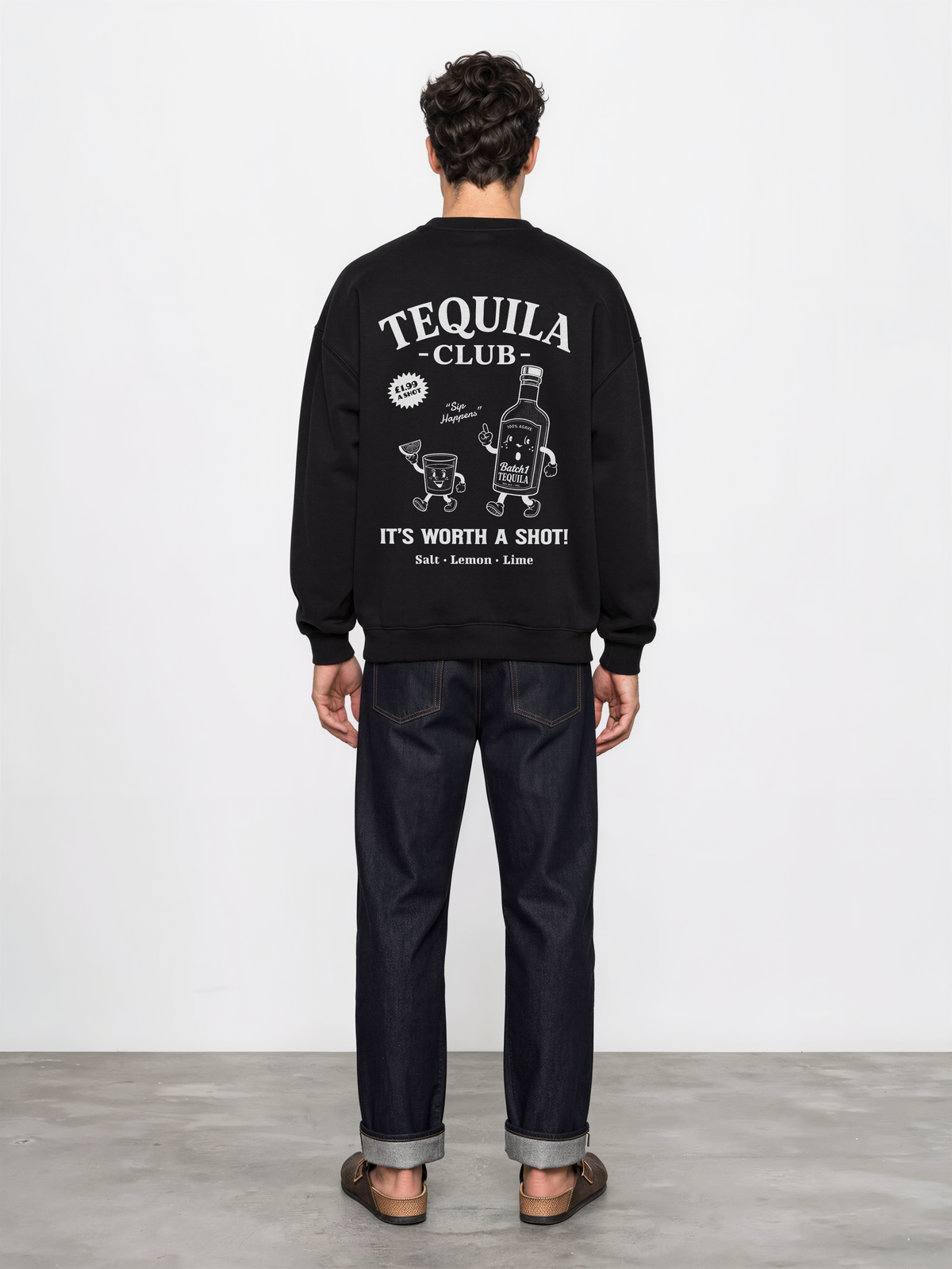 Male model wearing the black Tequila Club oversized sweatshirt, back view showing the large white tequila bottle and shot-glass graphic.