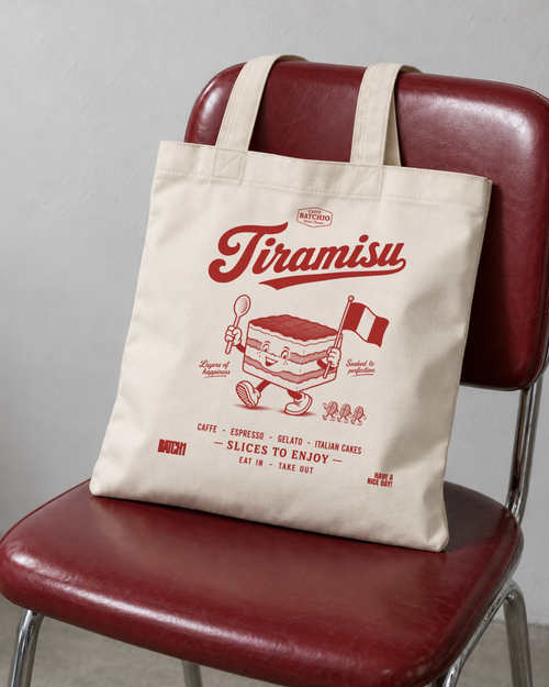 Tiramisu natural cotton tote bag with red café-style artwork resting on an oxblood café chair