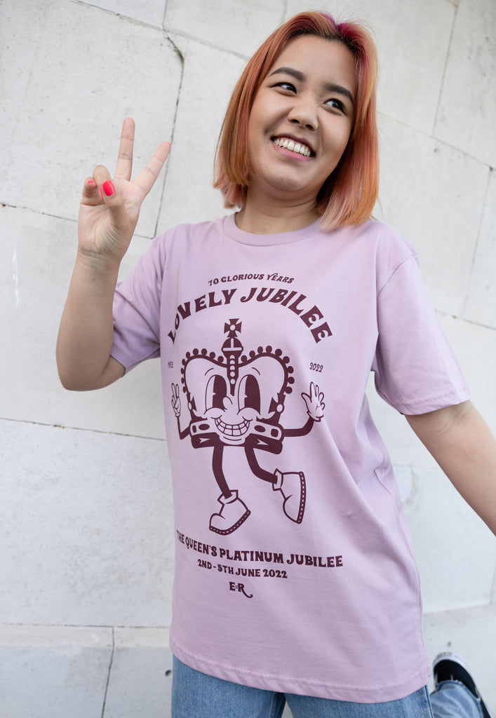 Model wears dusty purple unisex tshirt with 'Lovely Jubilee" slogan and crown character graphic