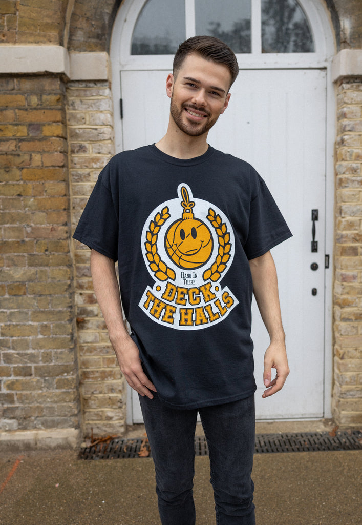 male model wears positive christmas slogan t shirt with happy face bauble graphic